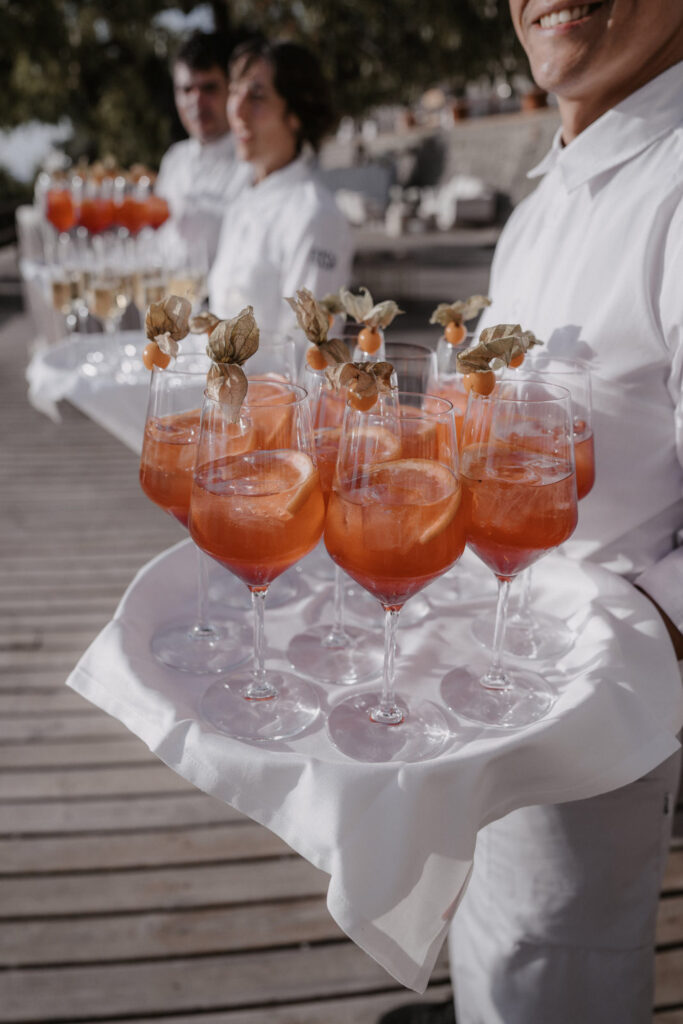 Wedding in Son Marroig: Getting married over the cliffs of Mallorca, with experience, costs and tips 20 In Son Marroig, a waiter carries a tray of orange-colored shot cocktails garnished with physalis.