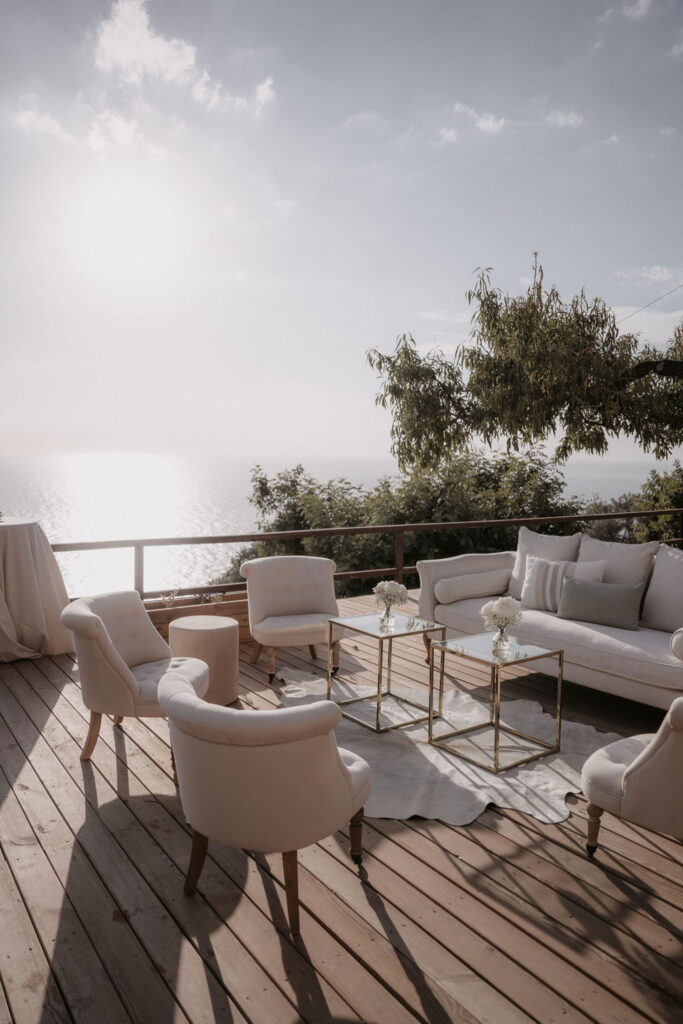 Weiße Loungemöbel auf einer Holzterrasse in Son Marroig mit Blick auf das Meer.