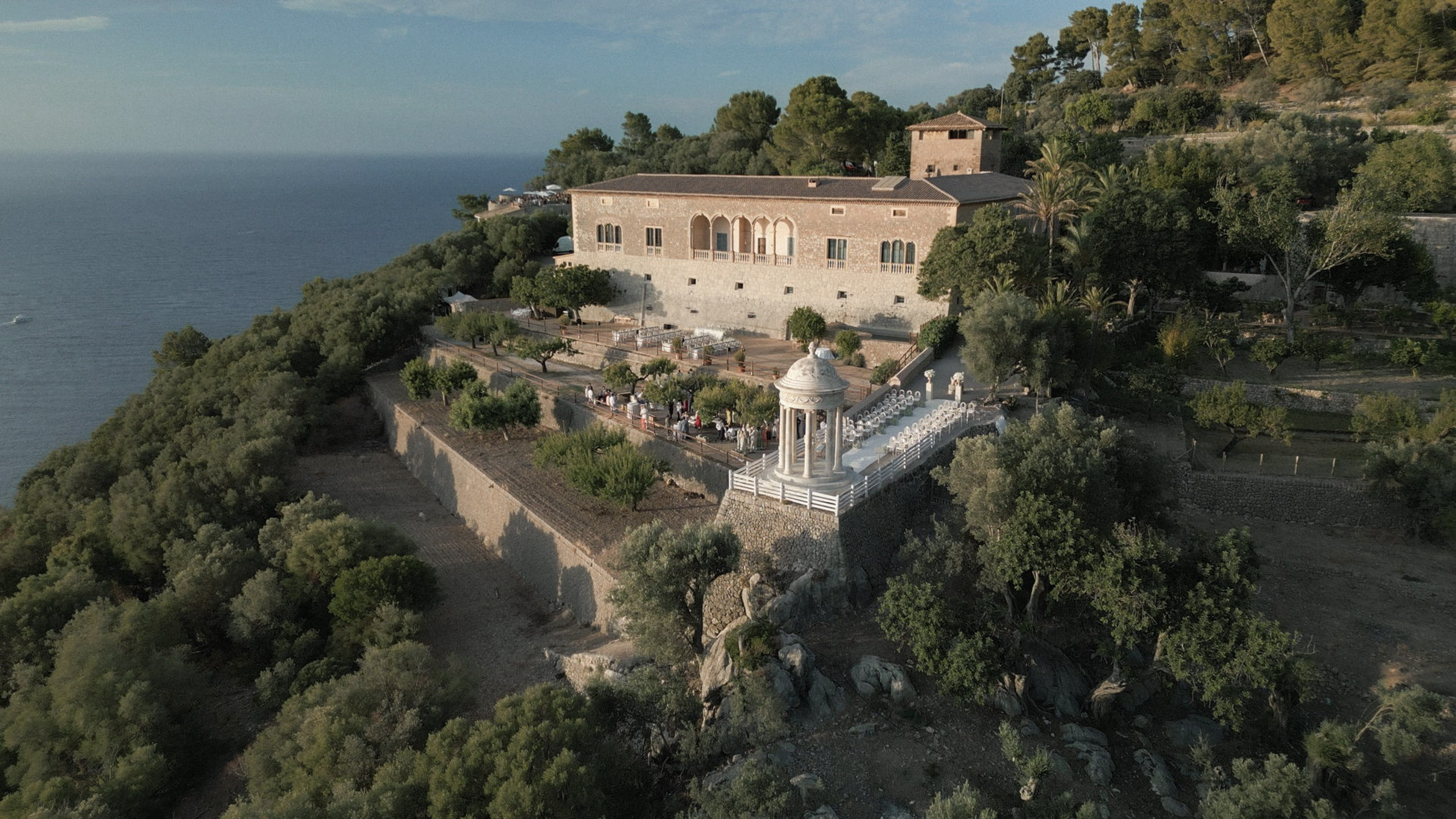 Wedding in Son Marroig: Getting married over the cliffs of Mallorca, with experience, costs and tips 1 Aerial view of the historic stone building Son Marroig and the pavilion on a cliff overlooking the sea.