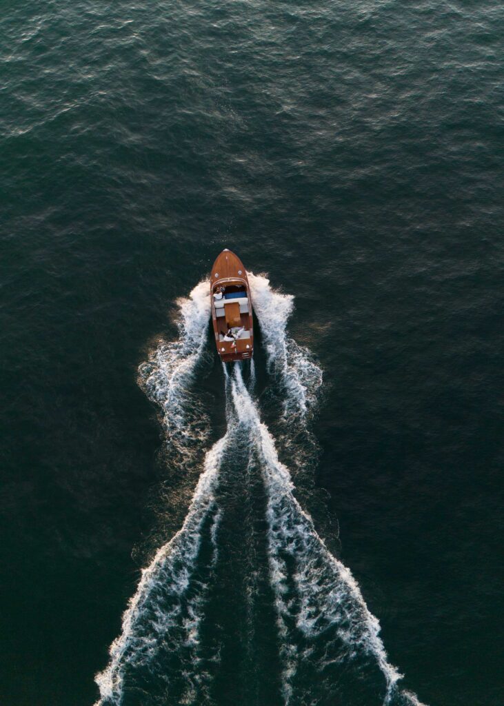Heiraten am Gardasee: Locations, Kosten und ehrliche Erfahrungen aus über 15 Hochzeiten 11 Ein Boot bewegt sich durch das dunkle Wasser und hinterlässt ein V-förmiges Kielwasser - ganz wie die eleganten Momente, die in Hochzeitsfotografie im Ausland eingefangen wurden.