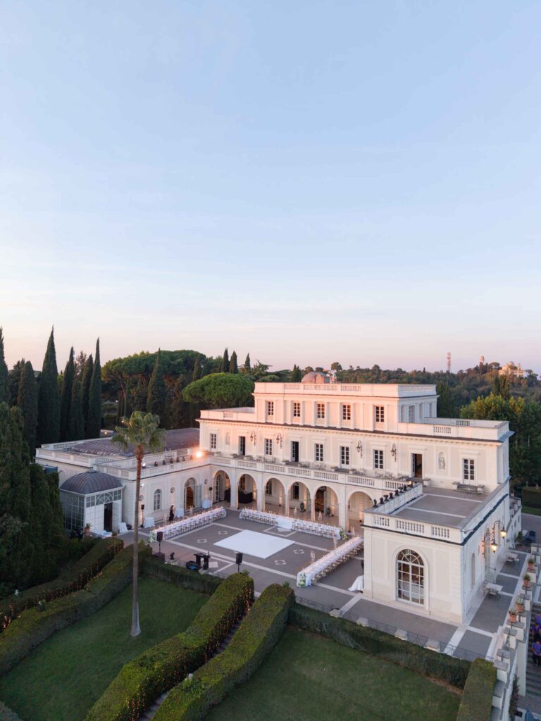 Luftaufnahme der Villa Miani mit langen Esstischen, die für eine Veranstaltung im Freien gedeckt sind.