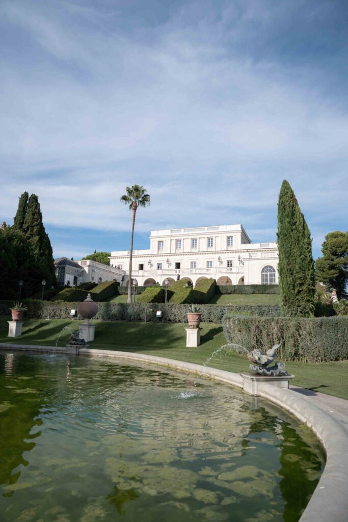 Die Villa Miani, ein weißes Herrenhaus mit terrassenförmig angelegten Gärten und einem Teich mit Springbrunnen.