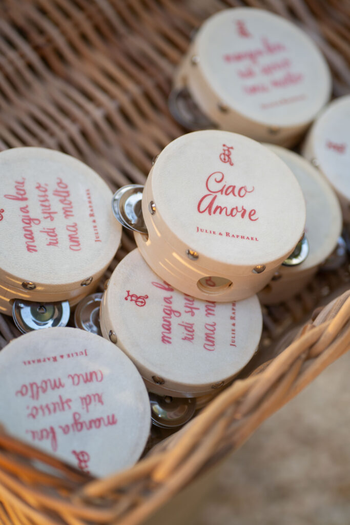 Small tambourines in a basket, decorated with red text featuring phrases like 'Ciao Amore' and other Italian expressions – perfect accents for holiday weddings or a touch of romance for wedding photography.