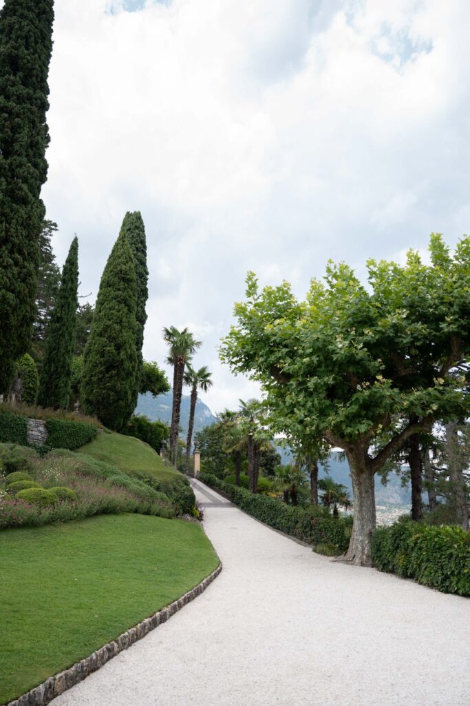 Villa del Balbianello Hochzeit: Kosten, Ablauf und die ikonischste Location am Comer See 42 A gravel path winds through the terraced gardens of Villa del Balbianello, which are lined with cypresses.