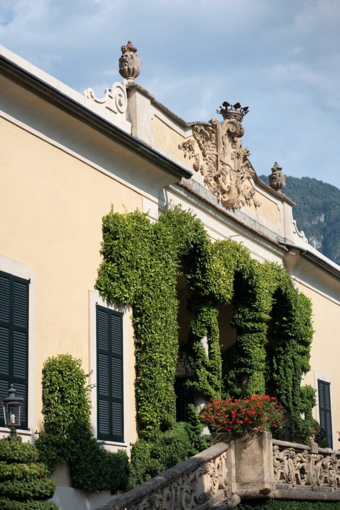 Villa del Balbianello Hochzeit: Kosten, Ablauf und die ikonischste Location am Comer See 38 The cream-colored Villa del Balbianello with ivy-covered arches and a stone coat of arms above the entrance.