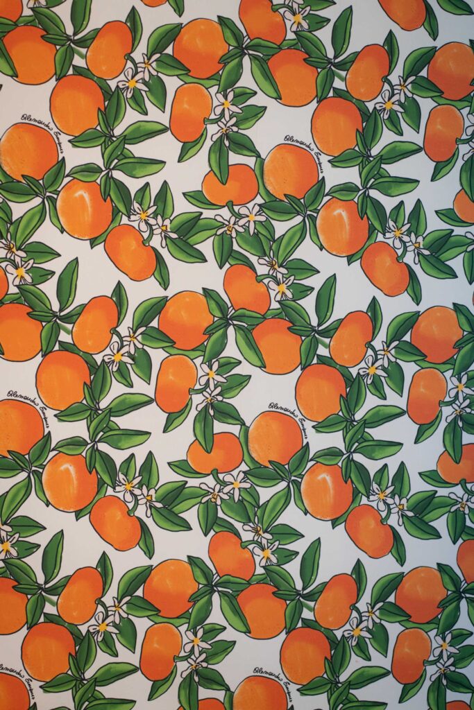 Muster aus abgebildeten Orangen, grünen Blättern und weißen Blüten auf weißem Hintergrund, inspiriert von der lebendigen Schönheit Siziliens in Italien.