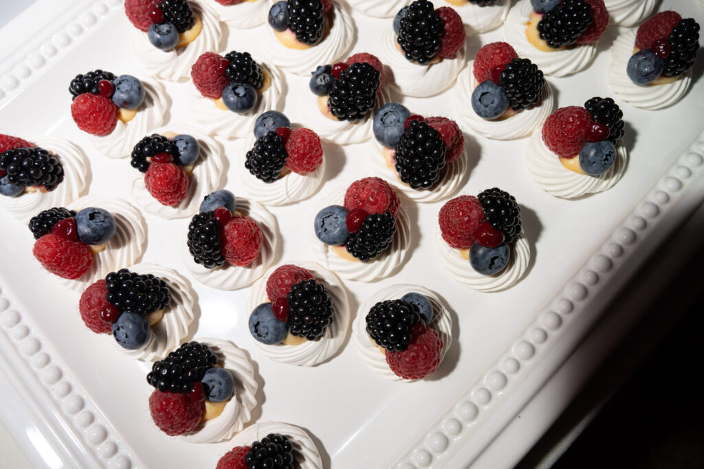 Kleine Meringues mit Brombeeren, Himbeeren und Heidelbeeren auf einem weißen Tablett – eine elegante Köstlichkeit, perfekt für jeden festlichen Anlass, kreiert von Stella Rheni, ideal für alle, die eine Hochzeit in Bonn planen oder davon träumen, in Bonn zu heiraten.