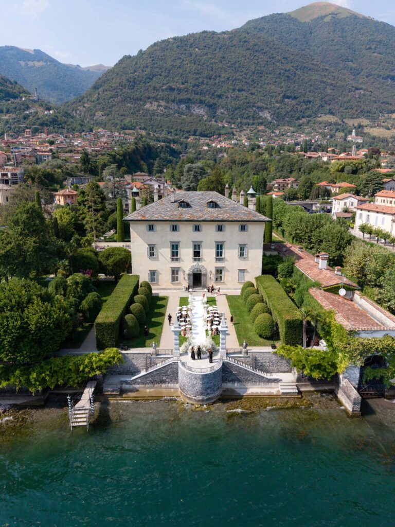 Luftaufnahme der Villa Balbiano, einer atemberaubenden Villa am See mit Garten, einer Veranstaltungsfläche im Freien und grünen Bergen im Hintergrund – ideal für eine Hochzeit am Comer See.
