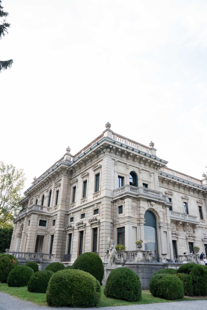Ein prächtiges, reich verziertes Herrenhaus aus Stein mit Bogenfenstern besticht durch einen Automatischen Entwurf und gepflegte Sträucher.