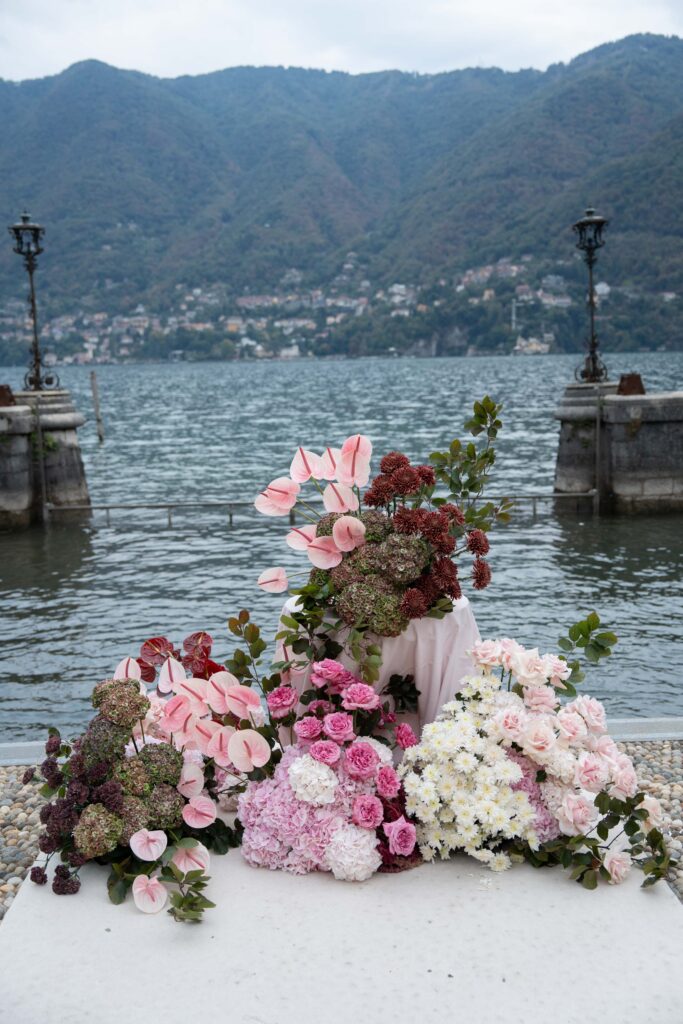 Blumenarrangement mit rosa und weißen Blüten an einem See – ein spontanes Spiegelbild der Schönheit der Natur.