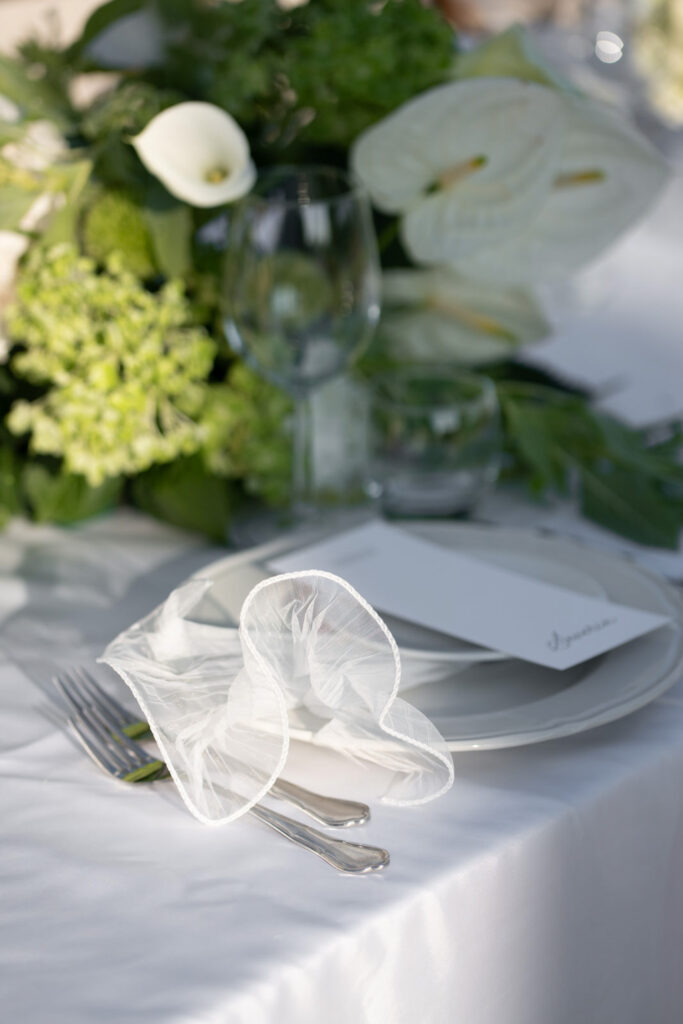 Hochzeit im Maniero Montecassiano: Euer Hochzeitswochenende in einer Boutique-Villa in den Marken 20 Ein Gedeck von Maniero Montecassiano mit einer Speisekarte und einer zarten Blume auf einem mit Blumen geschmückten Tisch.