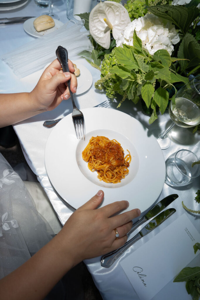 Hochzeit im Maniero Montecassiano: Euer Hochzeitswochenende in einer Boutique-Villa in den Marken 71 Eine Person, die bei einer feierlichen Veranstaltung im Maniero Montecassiano Pasta mit Fleischsoße isst.