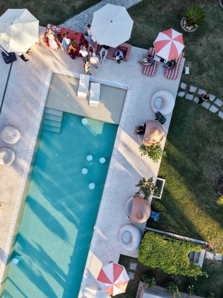 Hochzeit im Maniero Montecassiano: Euer Hochzeitswochenende in einer Boutique-Villa in den Marken 58 Luftaufnahme des Schwimmbads Maniero Montecassiano, umgeben von Menschen und Liegestühlen.