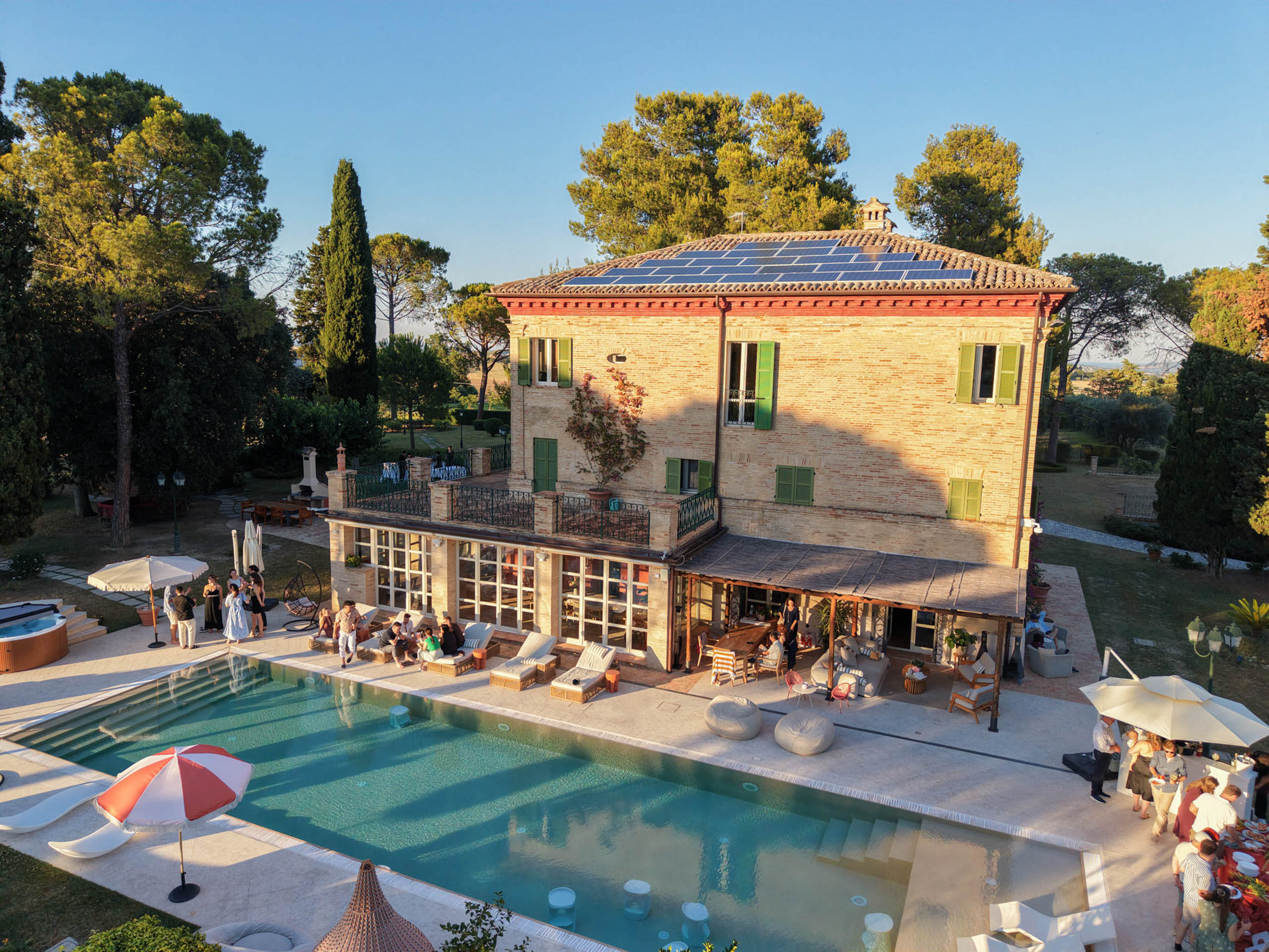 Eine kleine Villa aus Ziegelsteinen mit Sonnenkollektoren und Blick auf einen Pool an einem Hochzeitswochenende.