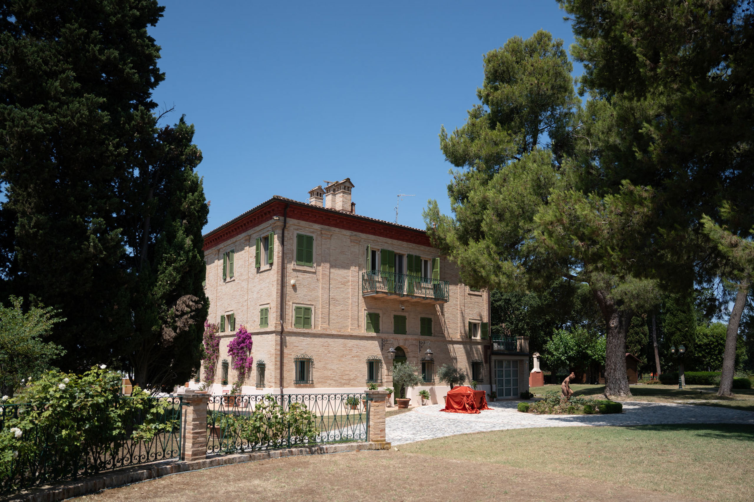 Hochzeit im Maniero Montecassiano: Euer Hochzeitswochenende in einer Boutique-Villa in den Marken 18 Maniero Montecassiano: eine dreistöckige Backsteinvilla mit grünen Fensterläden inmitten großer Kiefern.