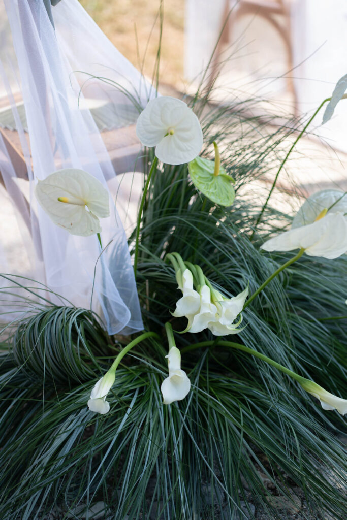 Hochzeit im Maniero Montecassiano: Euer Hochzeitswochenende in einer Boutique-Villa in den Marken 32 Blumenarrangement aus weißen Anthurien und Calla-Lilien mit hohen Gräsern für eine Hochzeit in den Marken.