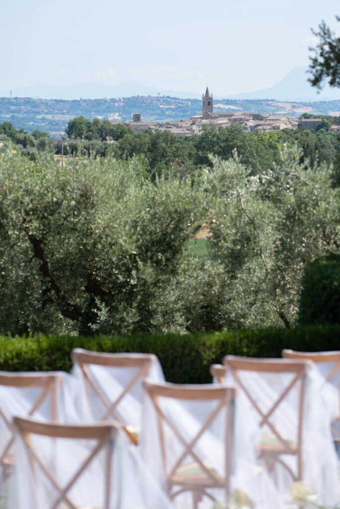 Hochzeit im Maniero Montecassiano: Euer Hochzeitswochenende in einer Boutique-Villa in den Marken 37 Hochzeitsstühle mit Blick auf ein italienisches Bergdorf bei einer Hochzeit in einer Boutique-Villa in Marken.