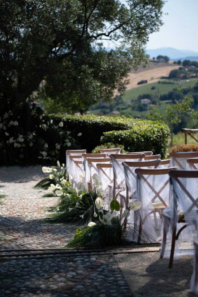 Hochzeit im Maniero Montecassiano: Euer Hochzeitswochenende in einer Boutique-Villa in den Marken 38 Reihen von Holzstühlen mit weißen Vorhängen, hergerichtet für eine Hochzeit im Maniero Montecassiano.