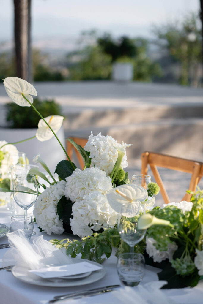 Hochzeit im Maniero Montecassiano: Euer Hochzeitswochenende in einer Boutique-Villa in den Marken 27 Weiße Hortensien und Anthurium-Blüten, arrangiert auf einem formellen Esstisch von Maniero Montecassiano.