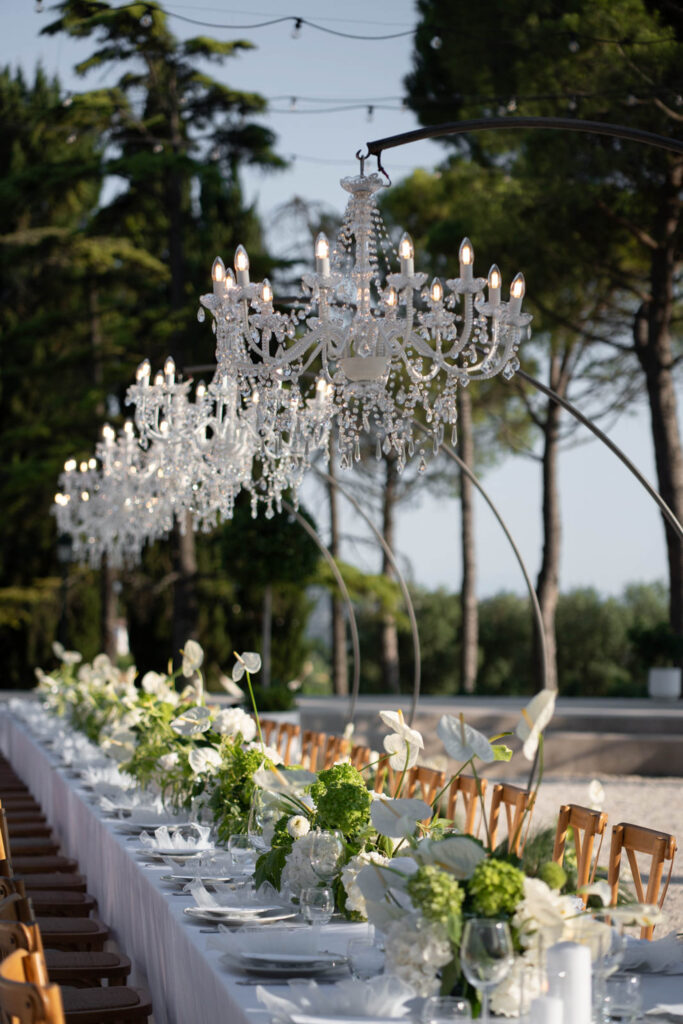 Hochzeit im Maniero Montecassiano: Euer Hochzeitswochenende in einer Boutique-Villa in den Marken 25 Ein langer Esstisch im Maniero Montecassiano, geschmückt mit weißen Blumen und Kristallkronleuchtern.