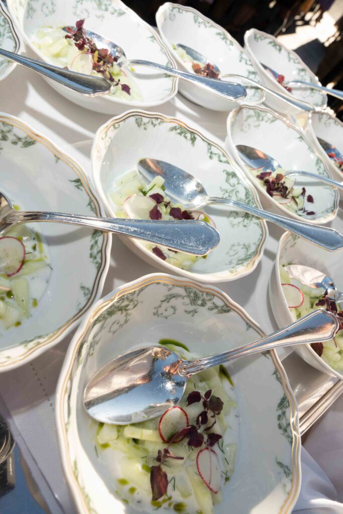 Kleine Schälchen mit Gurken- und Radieschensalat, serviert mit silbernen Löffeln, für eine Hochzeit im Schloss Fuschl aus Palisanderholz.