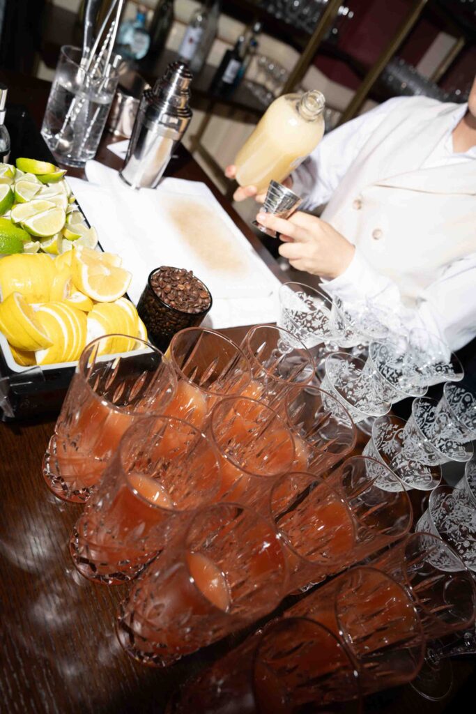 Ein Barkeeper mixt bei einer Hochzeit im Rosewood Schloss Fuschl Cocktails mit Zitronen und Kaffeebohnen.