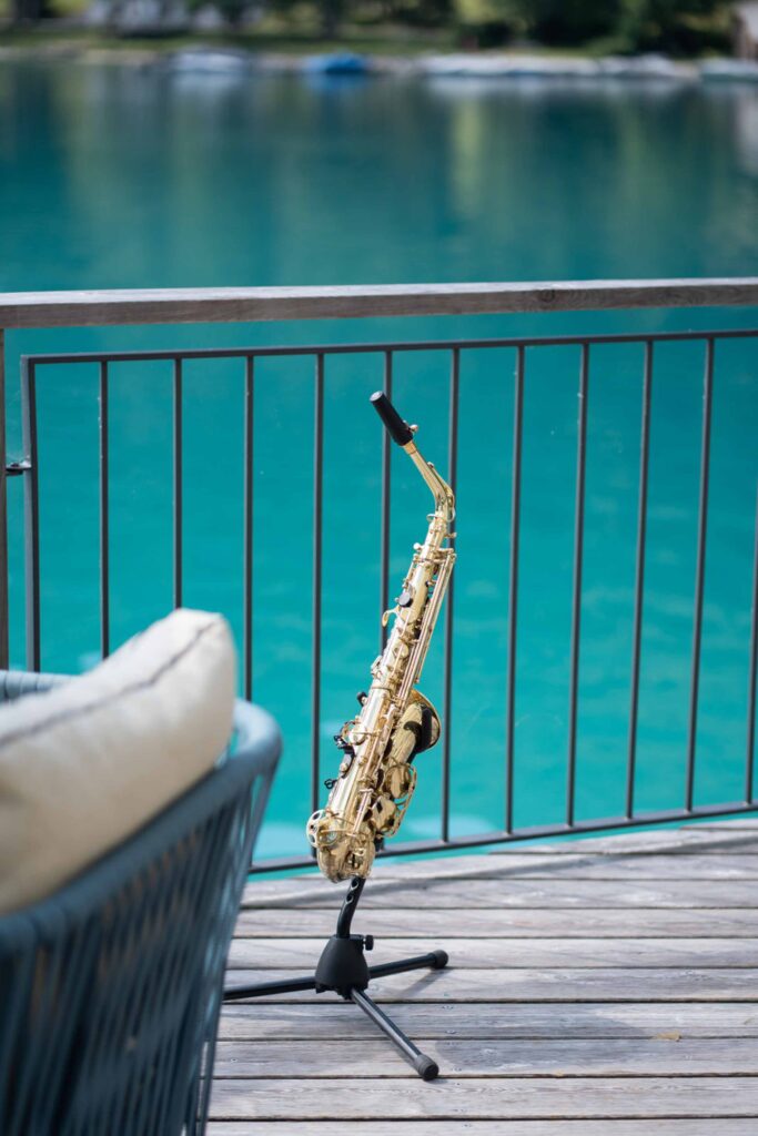 Ein goldenes Saxophon auf einem Ständer auf einer Terrasse mit Blick auf einen See am Schloss Fuschl.