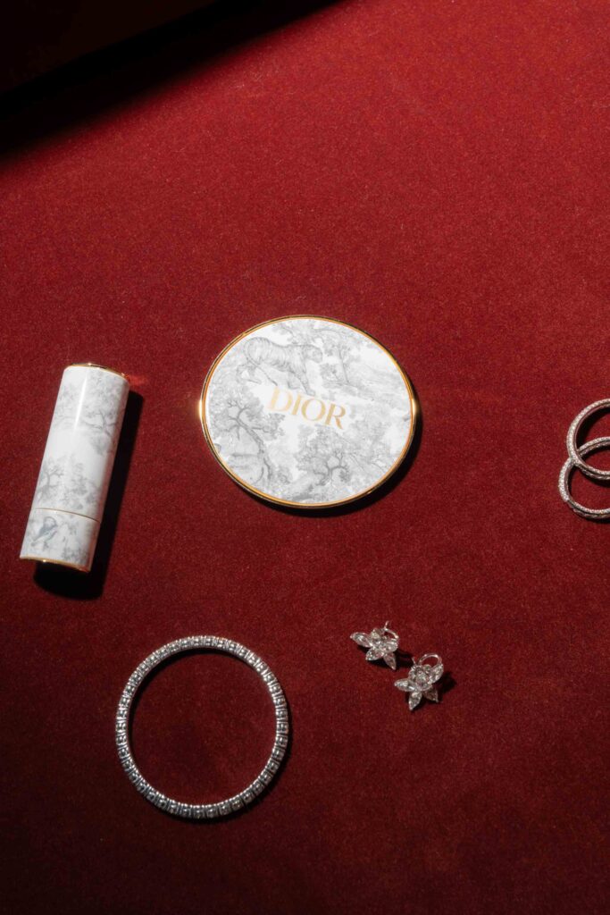 Dior-Kosmetik und -Schmuck, präsentiert auf rotem Samt bei einer Hochzeit im Rosewood Schloss Fuschl.