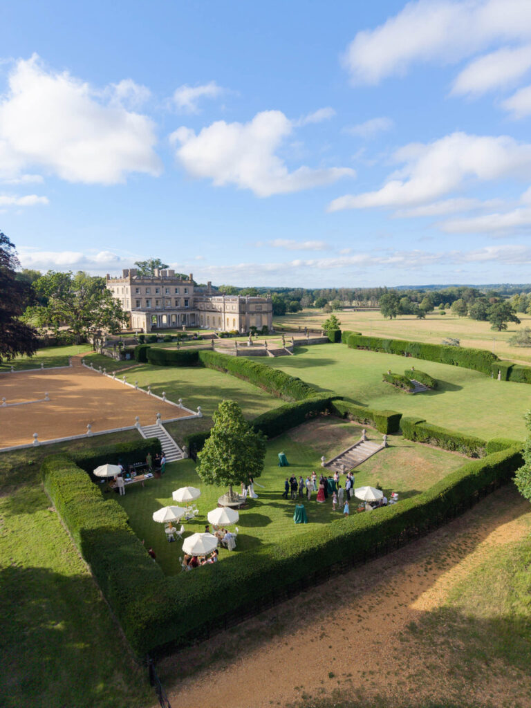 Luftaufnahme einer Gartenparty im Somerley House vor dem Hintergrund eines Anwesens im georgianischen Stil.
